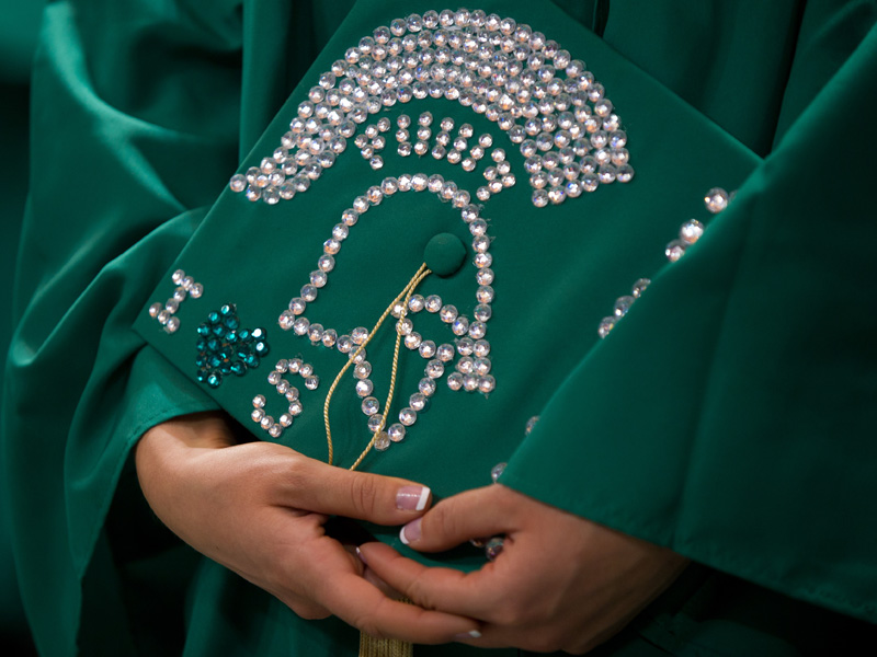 A graduate cap with a bedazzled Sparty helm and 