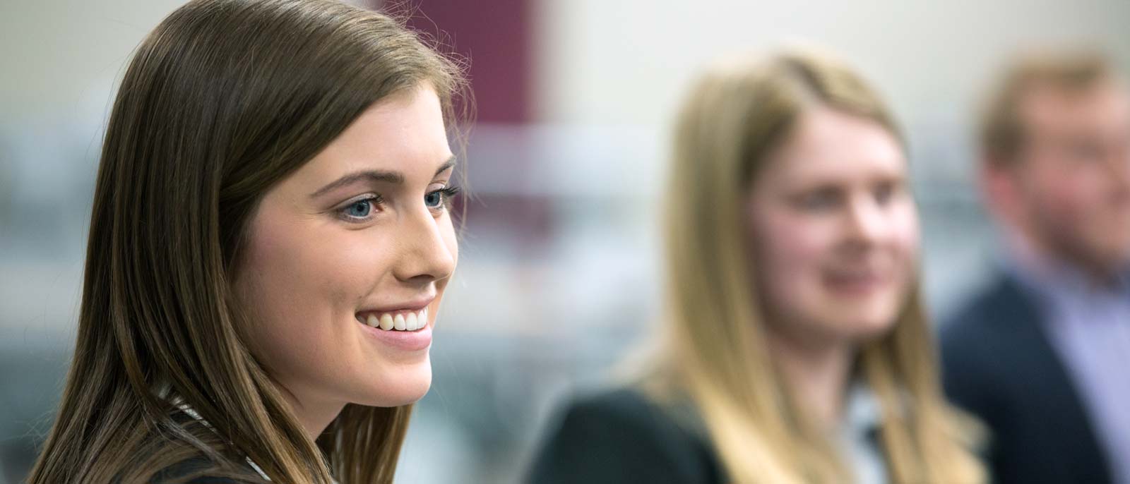 Two students smile as they listen in a business school course at Michigan State.