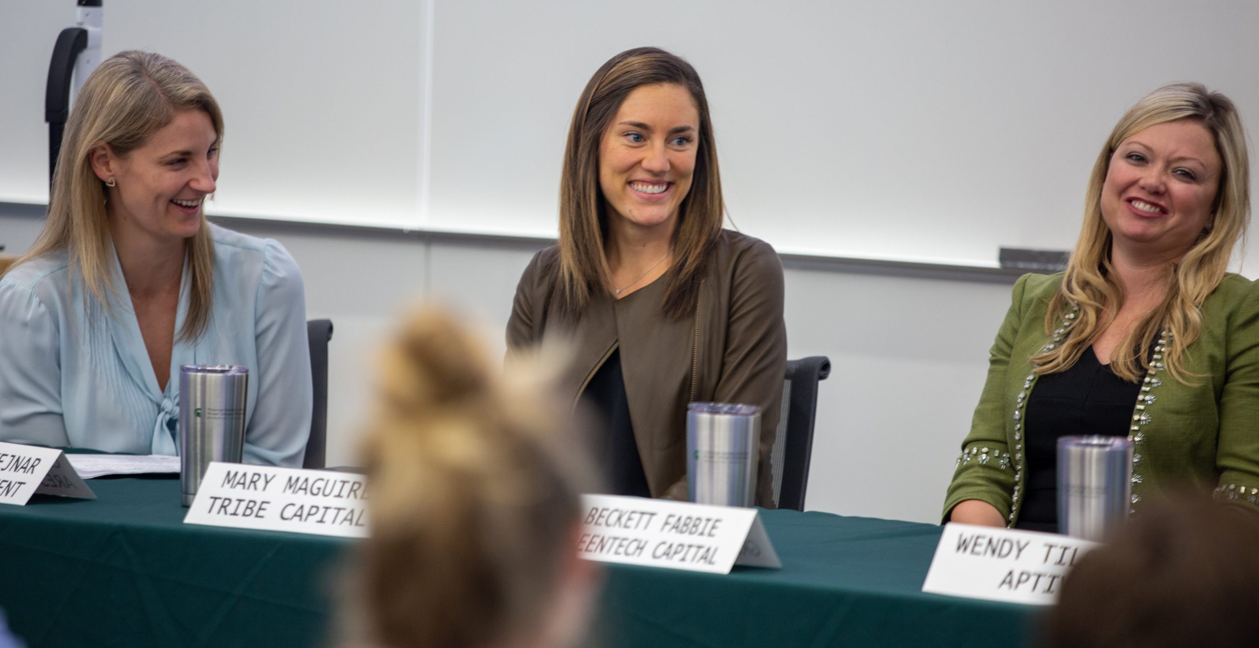 Three women in Finance sit at a panel table