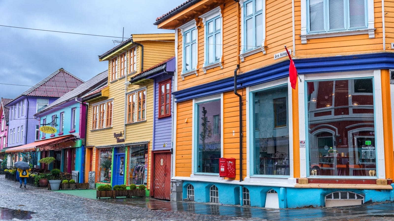 Stavanger - Norway. Colorful historic buildings with small shops and restaurants. Some people in the street.