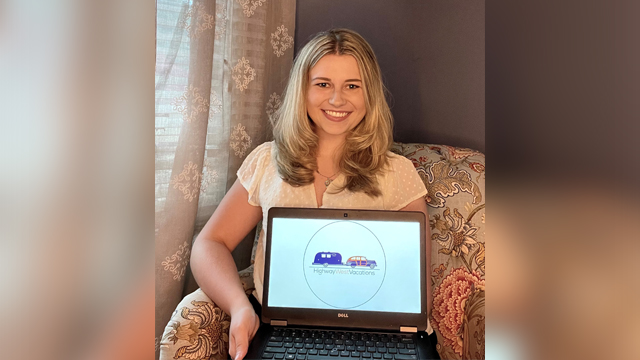 Caroline Waters poses with a laptop showing her company