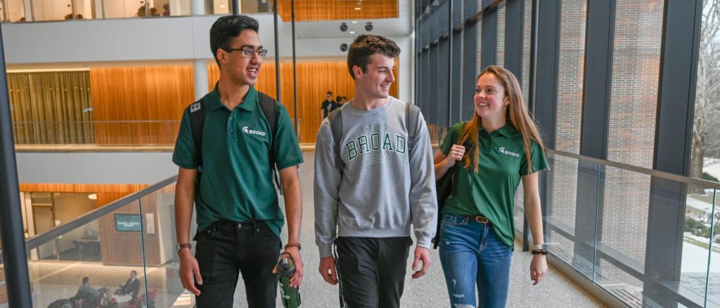 Three Broad College of Business undergraduate students walk together