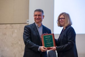 MSU Provost Teresa Woodruff presents Erkan Kocas, assistant director for international trade research at MSU-CIBER, with an award.