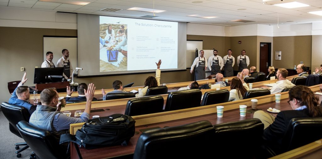 Students give a presentation to a room of people