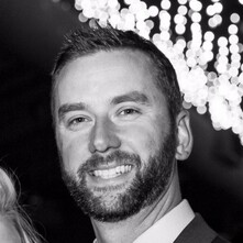 Black and white photo of man smiling at camera