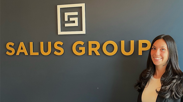 Maddison Rizzo posing in front of the Salus Group sign