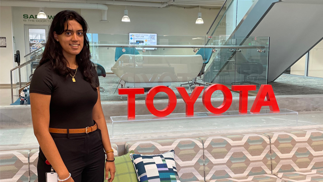 Abeeha Zaidi standing in front of the Toyota sign
