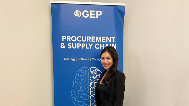 Abigaile Wu standing in front of a GEP banner