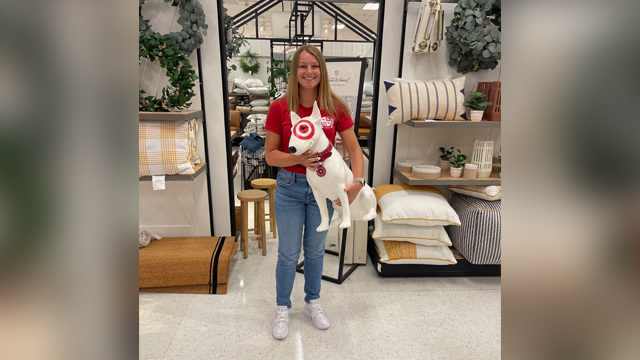 Emma Petrillo in Target store holding the target dog mascot sculpture
