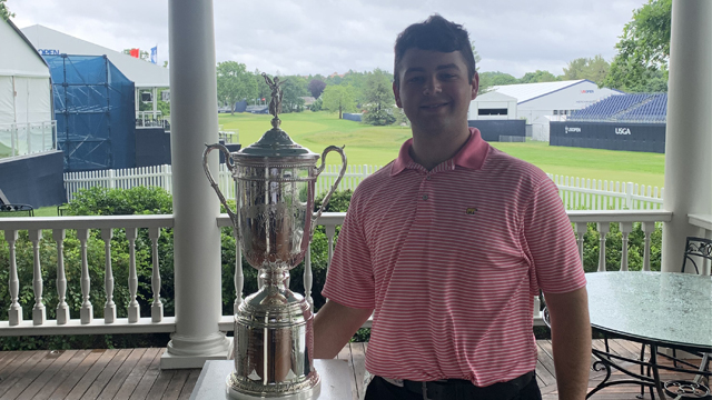 Joshua May standing next to the 122nd U.S. Open Championship Trophy for the United States Golf Association