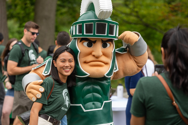 A Full-Time MBA student poses with MSU mascot Sparty at the 2022 MBA Welcome Picnic.