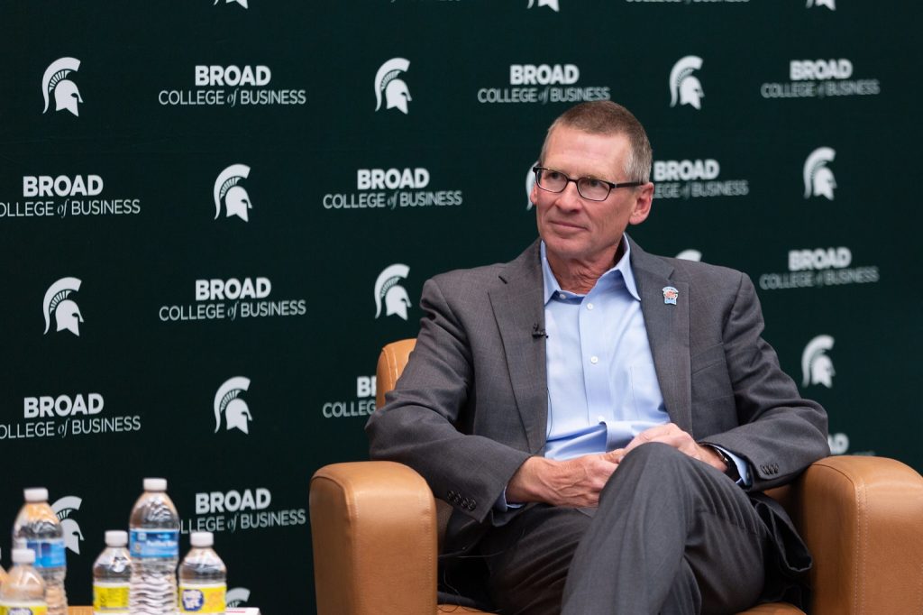 Wendy's CEO Todd Penegor sits in front of a Broad College step and repeat banner at the 2022 Warrington Lecture.