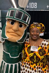 Brigitte Hall with MSU mascot Sparty insdie the Breslin Center for an event.