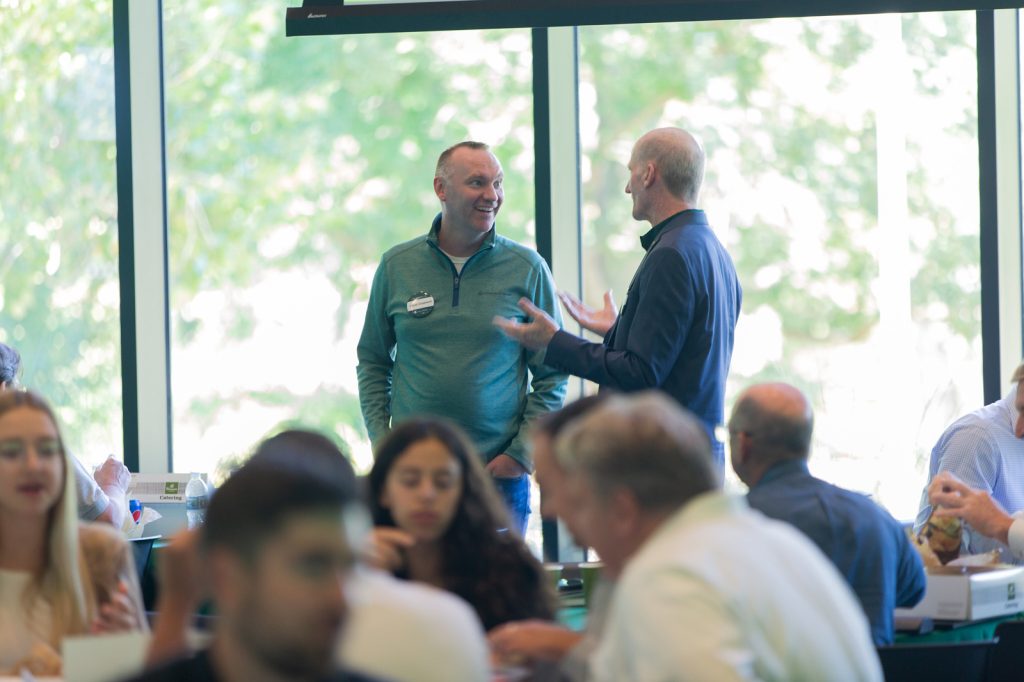 Two men stand and talk at the MSMR Spartan Insights Summit.