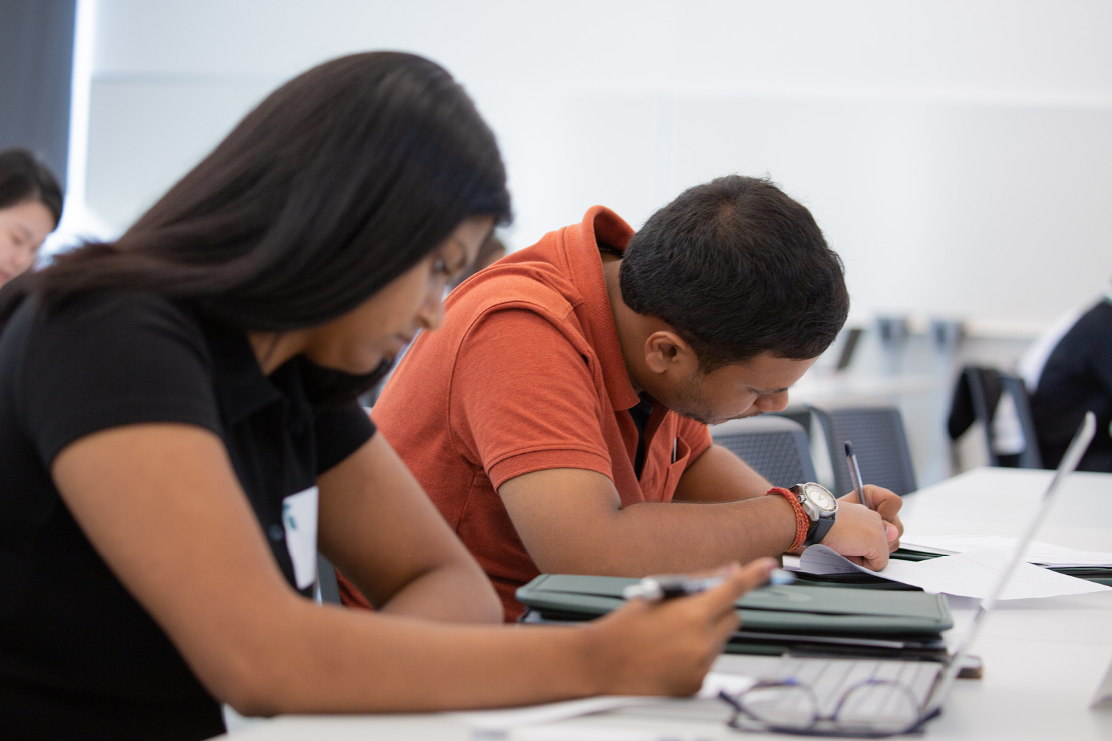 Two students take notes in a classroom in the Minskoff Pavilion.