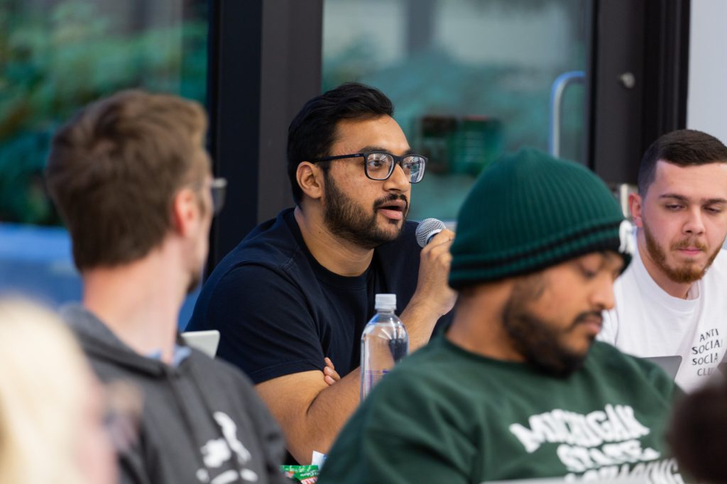 MBA student holding a microphone to ask a question in class.