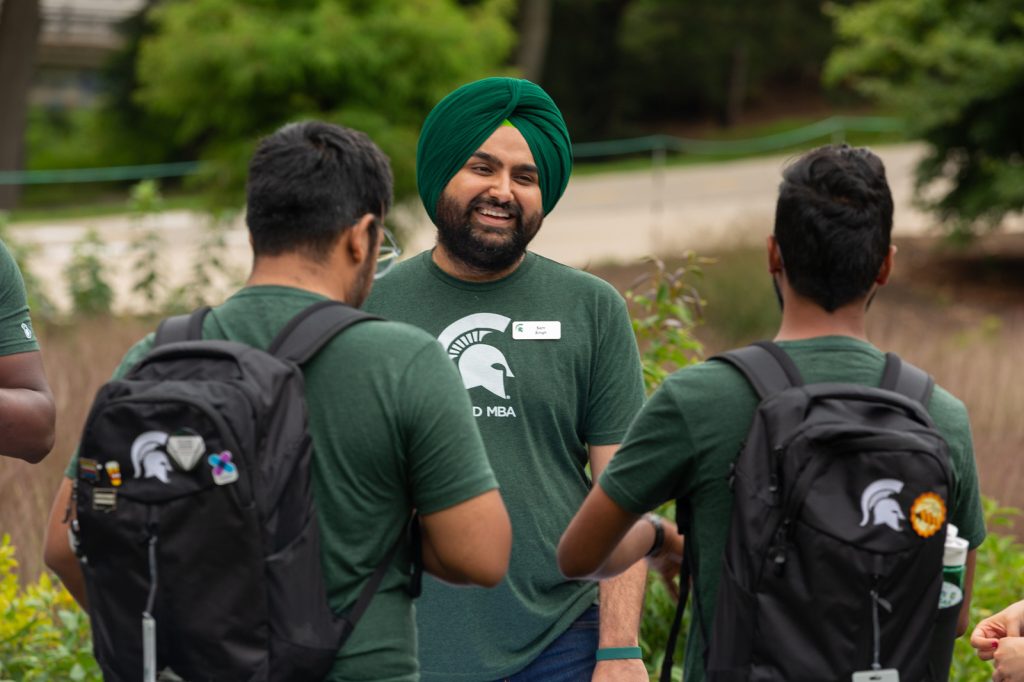 Broad Full-Time MBA students gather and talk outside for a program picnic.