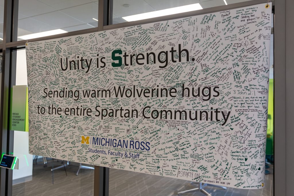A poster filled with signatures and messages of support surrounds large text that reads, 