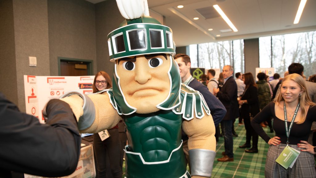 MSU mascot, Sparty, fist-bumping with someone at the 2022 Burgess New Venture Challenge