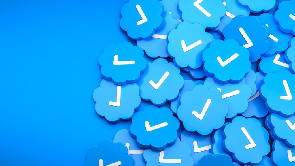 A pile of Twitter blue check marks on a blue background.