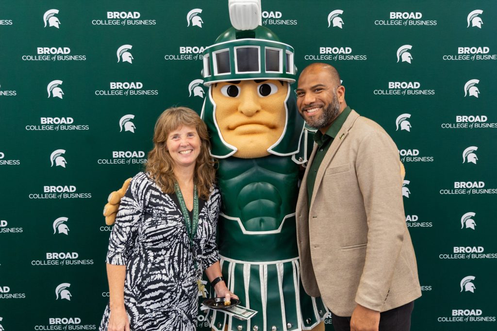 Cheri Speier-Pero and Ed Tillett pose with MSU mascot Sparty at the 2022 Broad College ice cream social and resource fair.