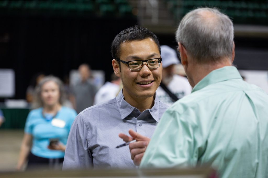 Guanglong Pang talks with another person at the 2023 UURAF.