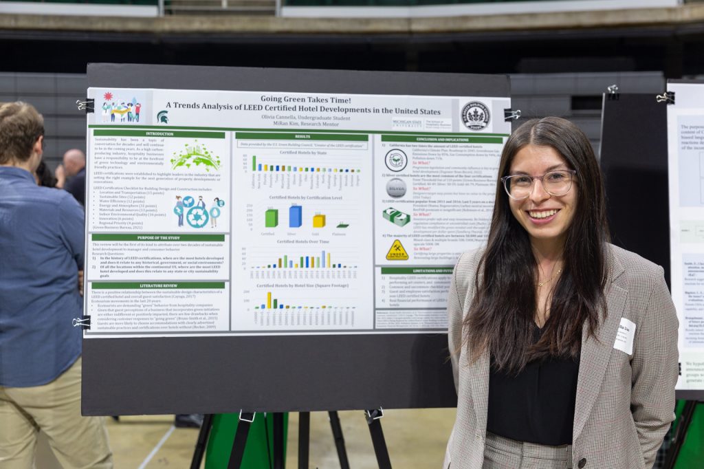 Olivia Cannella stands next to her poster at 2023 UURAF.