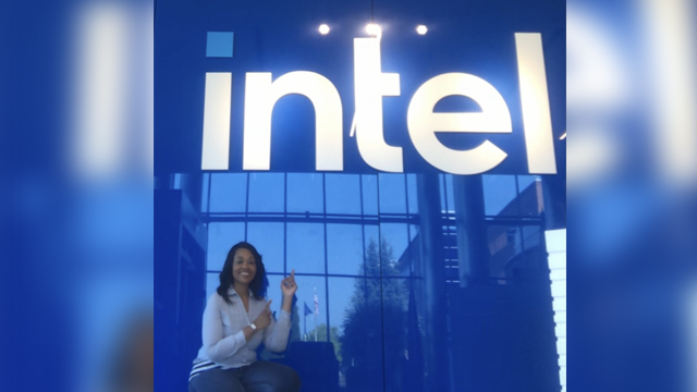 Amy Brothers posing in front of the Intel sign