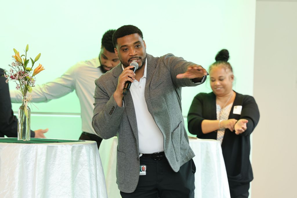 Ashton Henderson gestures while speaking into a microphone at the MSU NIL Summit.