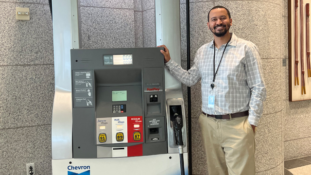 Bryce Chatman posing next to a Chevron gasoline pump