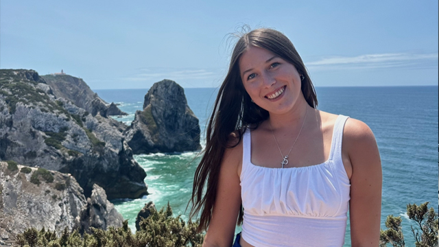 Ellie Plunkey posing in front of the water in Libson, Portugal