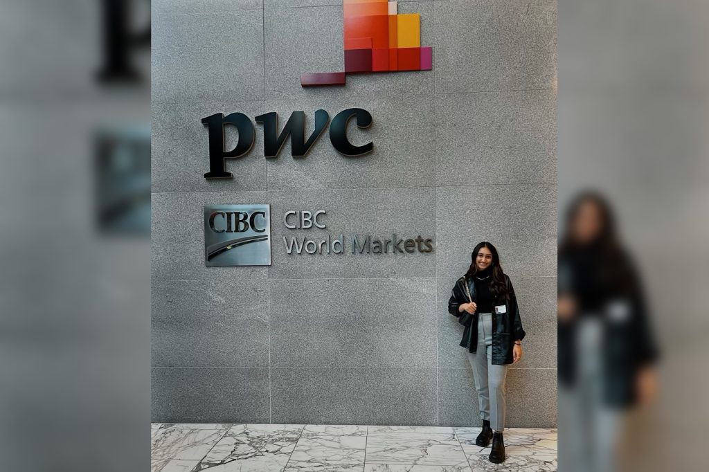 Riya Patel stands in front of PwC CIBC World Markets building signage during her 2023 internship experience.