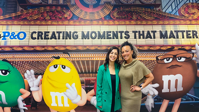 Tania Sotelo Valencia posing with another person in front of a mural