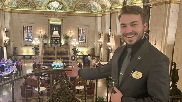 Tyler Dahms smiling and posing inside of the Palmer House hotel