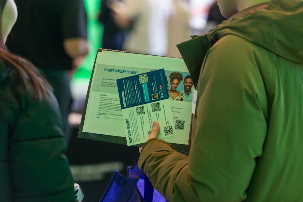 Close up view of Spartan holding brochures and pamphlets at a recruiting event.