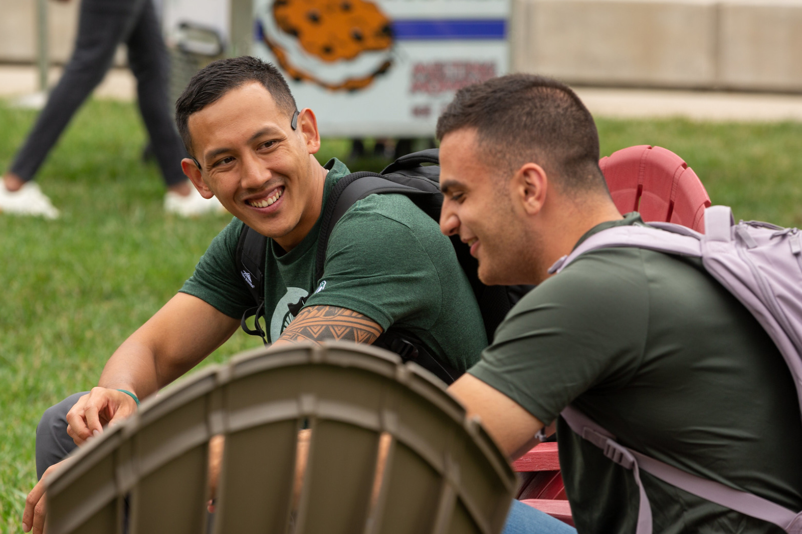Two Full-Time MBA students sit and talk at a fall welcome event on campus.