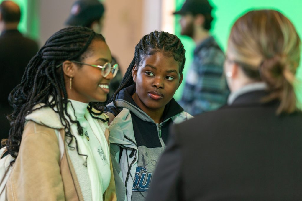 Two Spartans talk and engage with recruiters at a career fair event.