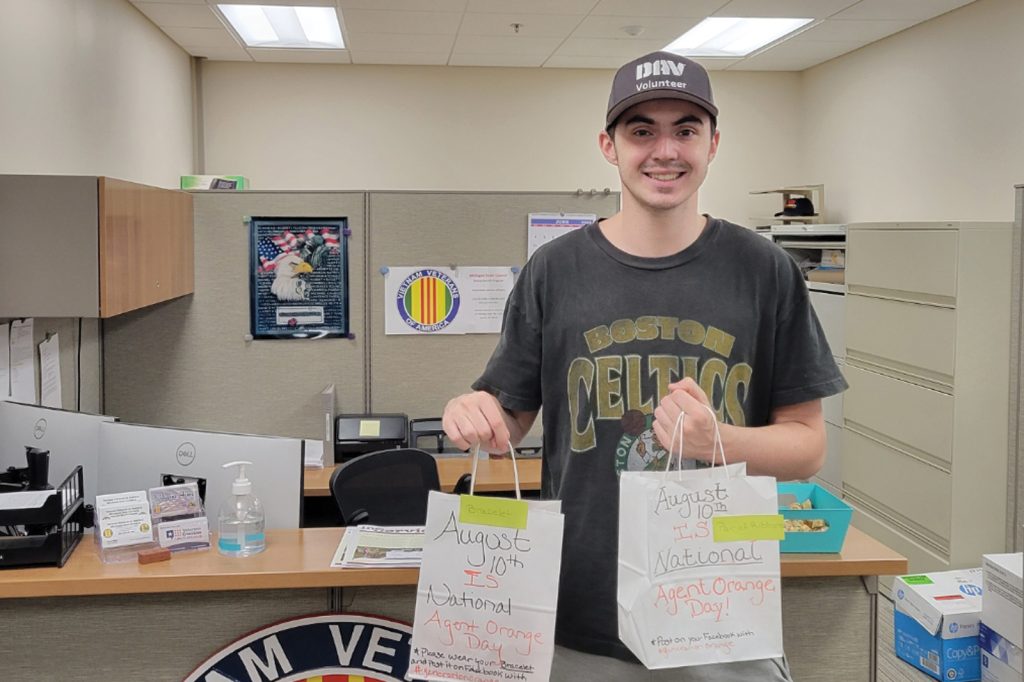 Jacob Weber holds gift bags with donations for Agent Orange day.