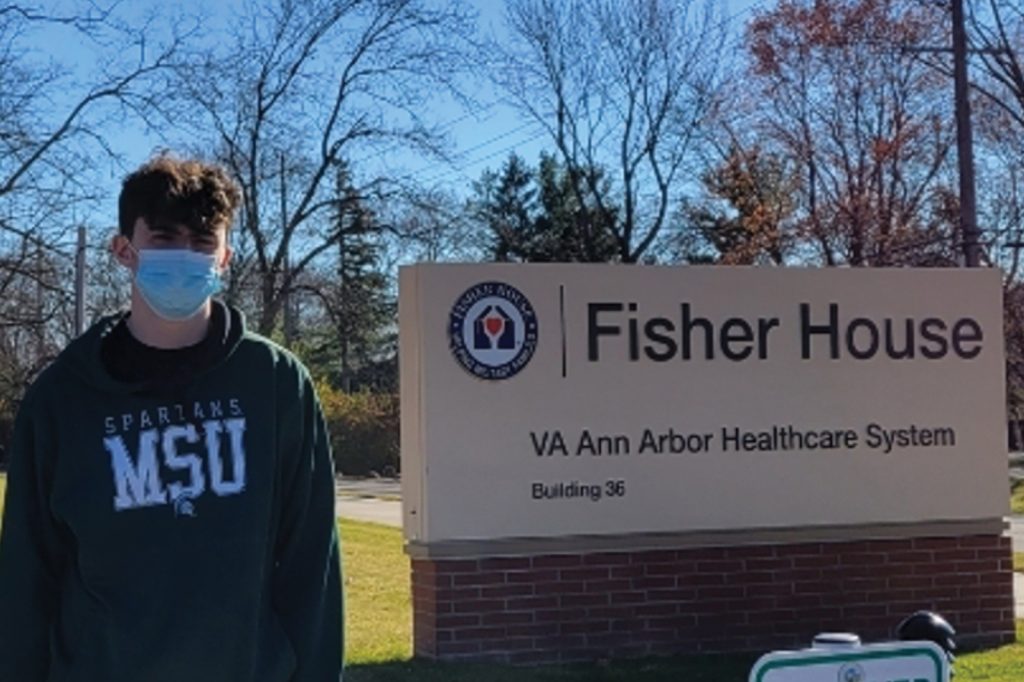 Jacob Weber poses near the Fisher House outdoor signage.