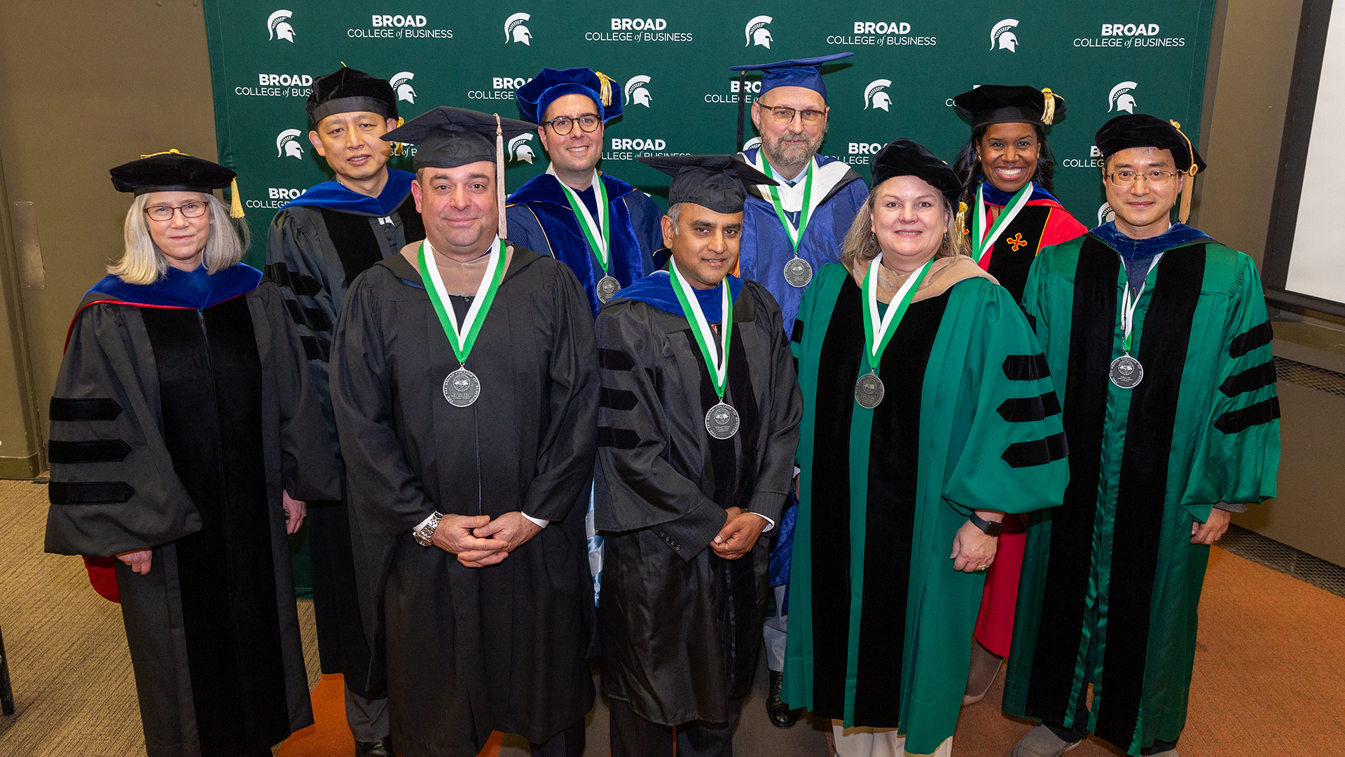 Broad faculty wear academic regalia and pose for a group picture at the 2023 Investiture Ceremony.