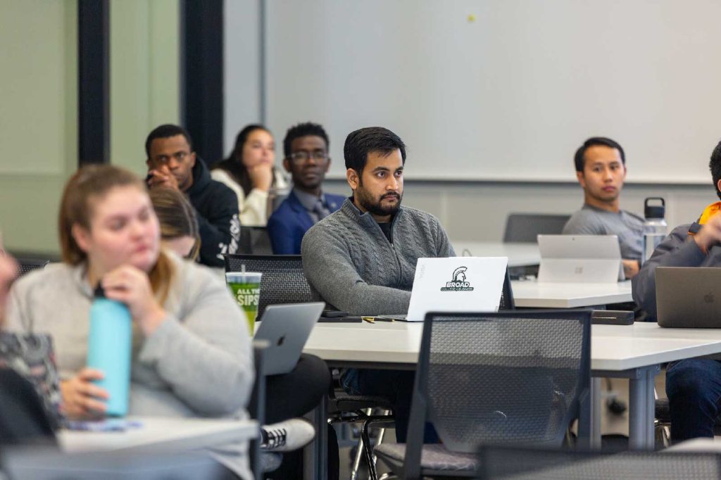Broad MBA students take notes in a classroom on laptop computers.