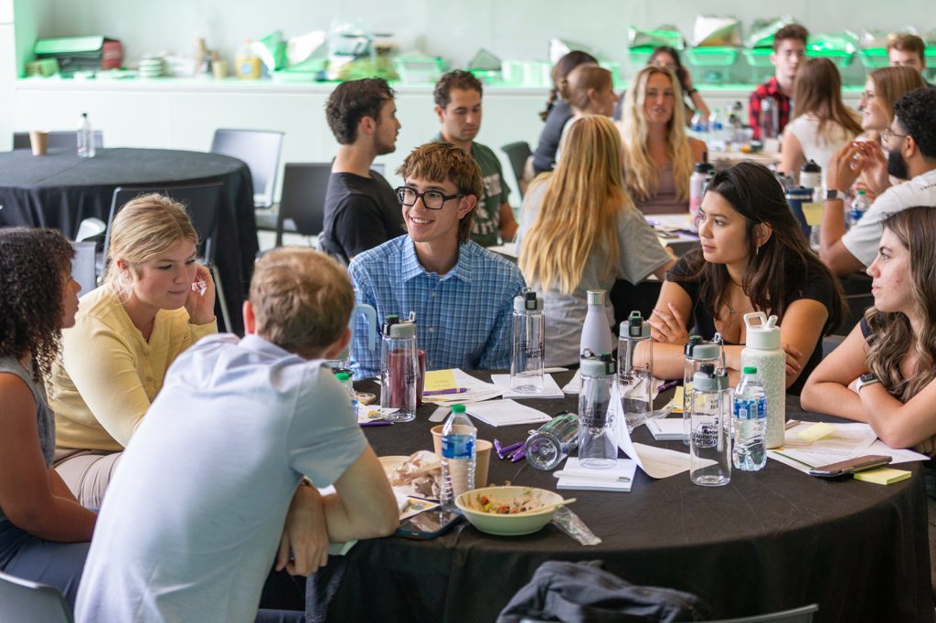 Group of students sitting at a table and working together towards inclusive excellence at a workshop.