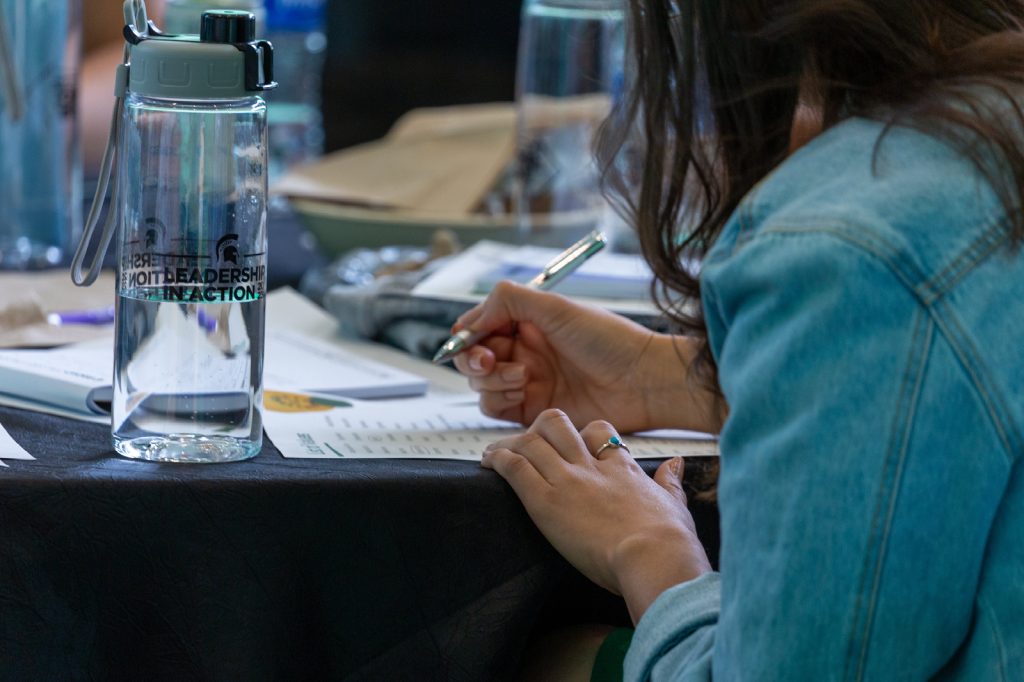 Close up of student taking notes on inclusive excellence while at a Leadership in Action workshop.