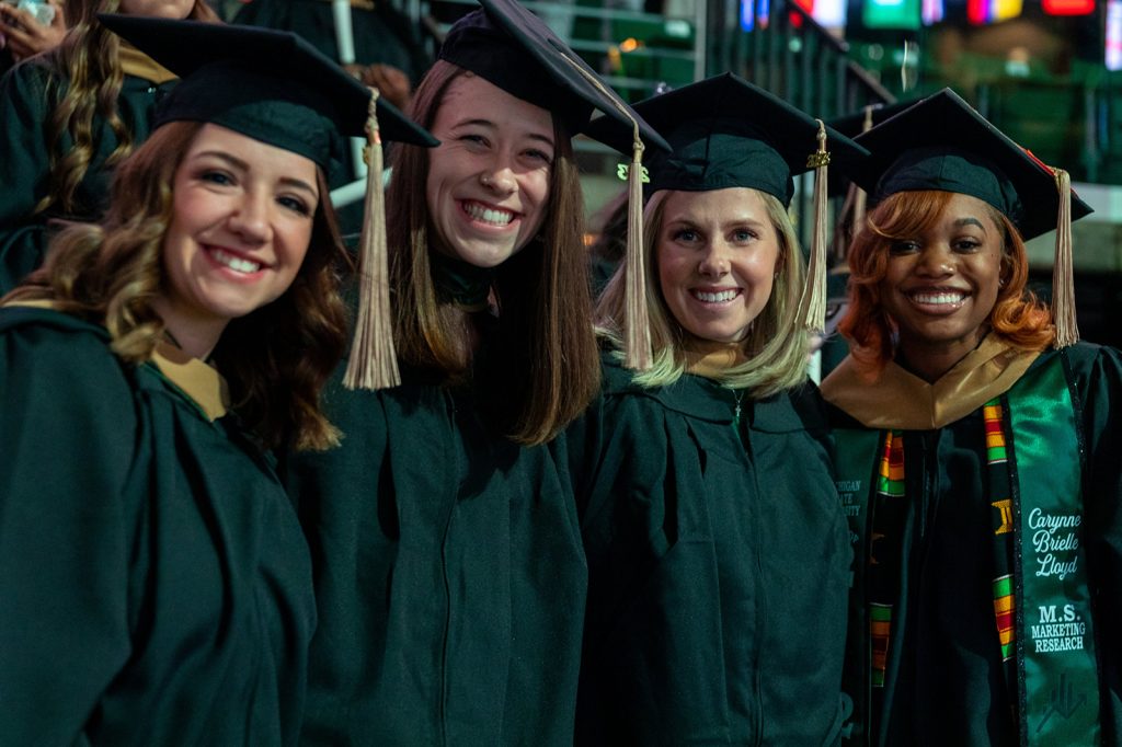 A group of Broad Spartans stand together for a photo at the master's commencement ceremony in the Breslin Center.