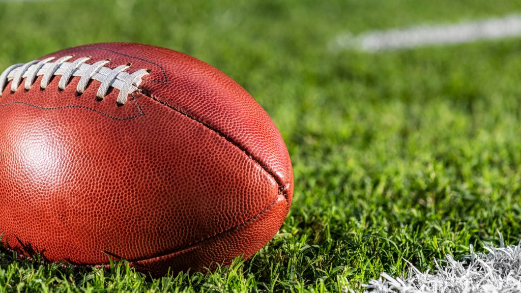 Close up football nestled on field.