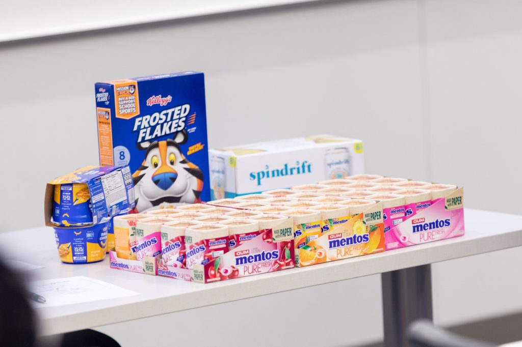 American breakfast cereal, snack foods and more on display on a classroom table.