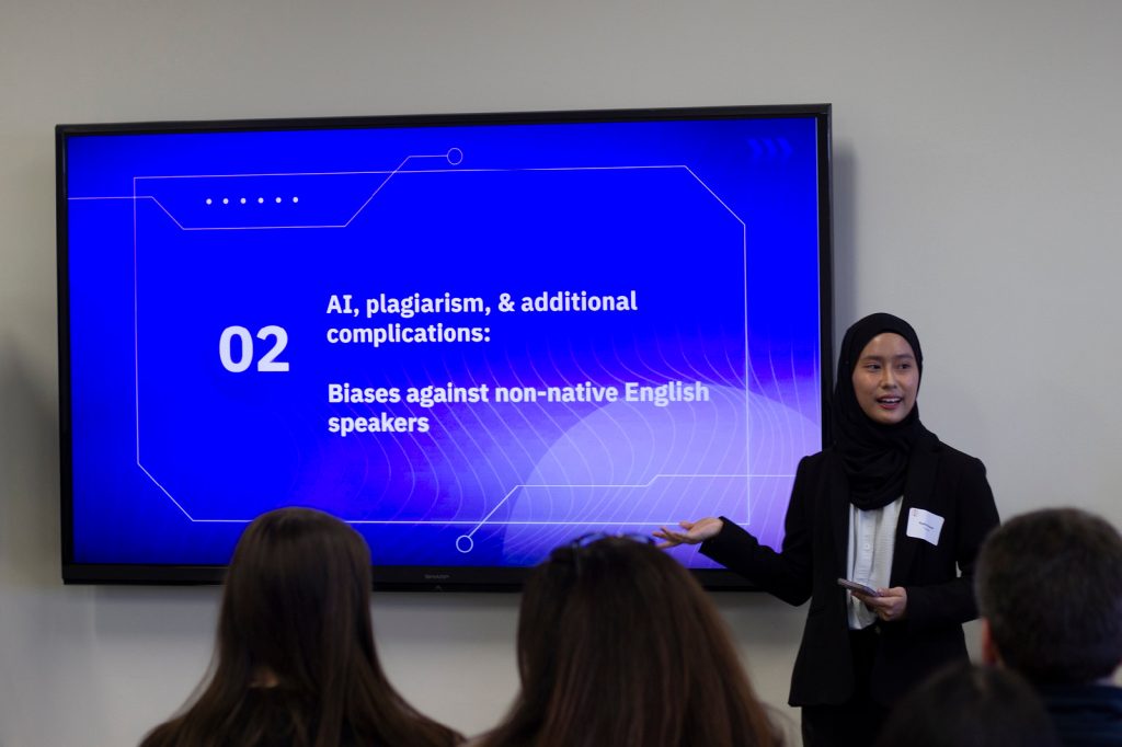 A student stands and presents a powerpoint slide on AI plagiarism at the 2024 Diversity Research Showcase.