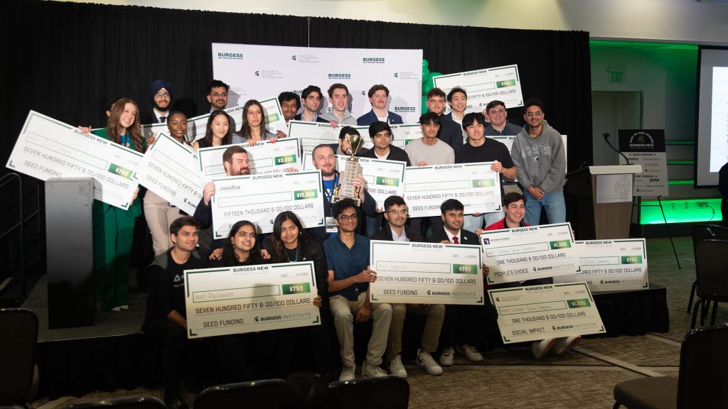 Spartan winners smile and hold oversized checks at the 2024 Burgess New Venture Challenge.
