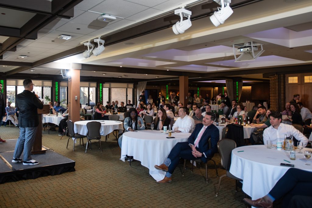 Spartans presenting a PowerPoint to a packed room during the 2024 EMBA Pitch Competition.