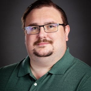 Man wearing green button down and glasses.